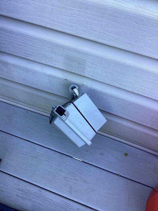 Replaced exterior deck outlet assembly with new weatherproof GFCI-protected configuration featuring four outlets in a black enclosure with clear protective cover and white conduit. Installation includes dual-section setup with GFCI outlet on left side and standard duplex outlet on right side, all properly grounded and secured to building exterior siding.