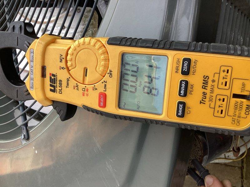 Completed scheduled cooling season tune-up on residential A/C unit located on side of home. Performed comprehensive system diagnostics including electrical testing of blower motor assembly and compressor components using digital multimeter and clamp meter to verify proper amperage draw and voltage readings. All measurements fell within manufacturer specifications at 294.5V and 34.4A. Inspected blower motor housing, fan assembly, and associated wiring connections. System operating normally with no deficiencies noted.