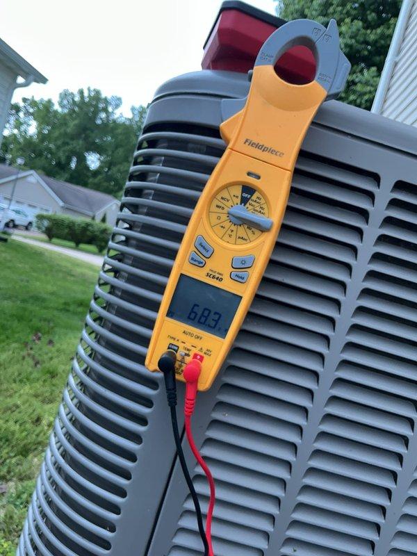 Completed cooling system tune-up on single outdoor AC unit located on basement pad. Performed comprehensive system diagnostics including electrical measurements with amperage reading of 6.09 amps at condenser and voltage testing showing 240V at disconnect panel. Inspected and tested dual-run capacitor, verified all electrical connections, and confirmed proper compressor operation on unit less than ten years old.