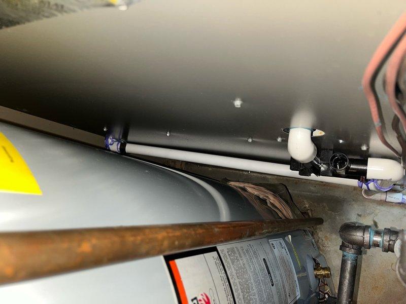 Returned to property to re-route condensate drain line for new HVAC installation. Ran approximately 20 feet of 3/4" PVC piping behind furnace and over floor drain, utilizing two couplings and one 90-degree elbow fitting to properly configure drainage path. Removed and discarded previous condensate line configuration, securing new PVC run with appropriate clamps and ensuring proper pitch for drainage. System tested and confirmed operational with heat and cooling functions verified.