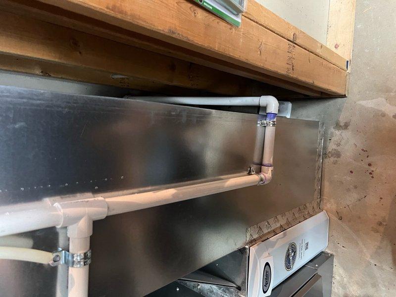 Returned to property to re-route condensate drain line for new HVAC installation. Ran approximately 20 feet of 3/4" PVC piping behind furnace and over floor drain, utilizing two couplings and one 90-degree elbow fitting to properly configure drainage path. Removed and discarded previous condensate line configuration, securing new PVC run with appropriate clamps and ensuring proper pitch for drainage. System tested and confirmed operational with heat and cooling functions verified.