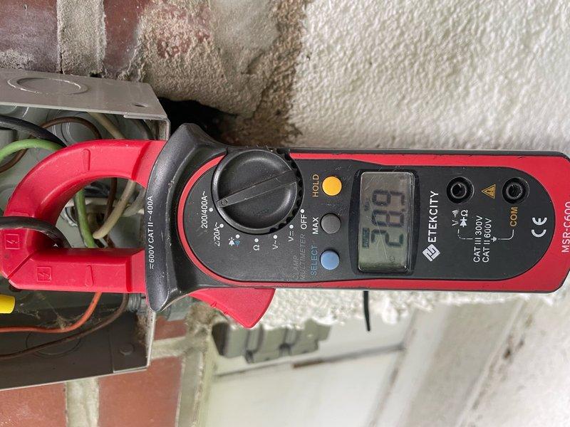 Responded to no cooling complaint on residential air conditioning unit located in backyard. Upon arrival, confirmed unit was running but delivering warm air to conditioned space. Performed electrical diagnostics using clamp meter to measure amperage draw at outdoor unit. Identified low amperage reading of 6.5 amps at compressor circuit, indicating potential compressor failure or refrigerant system issue. Documented electrical measurements at junction box and compressor terminals for diagnostic purposes.