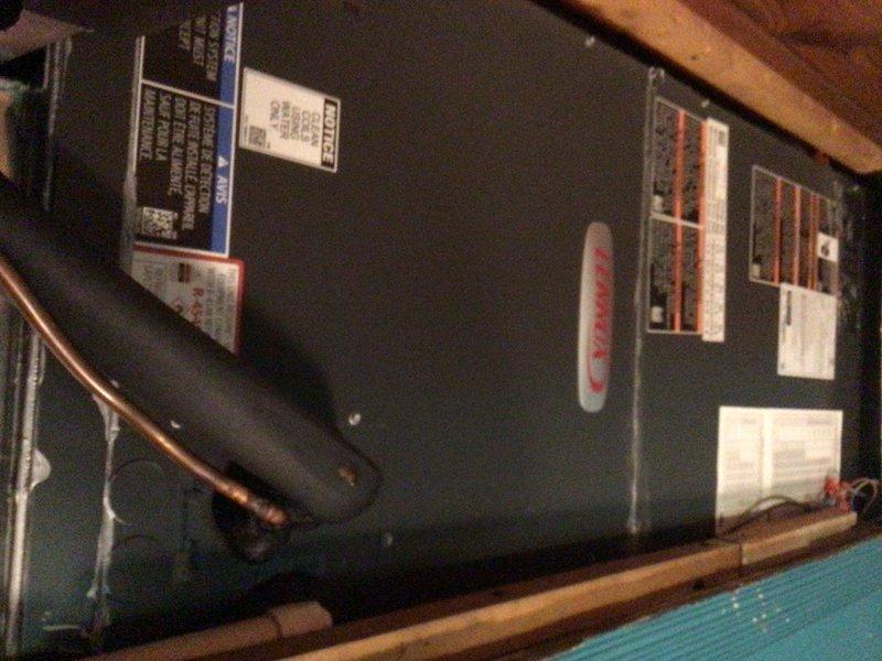 Responded to callback for blank Lennox iComfort thermostat on recently installed system less than one year old. Inspected attic-mounted air handler and verified proper power supply to unit and thermostat wiring connections. Documented equipment installation including Lennox air handler with all specification labels intact and proper mounting on structural framing. System restored to full operational status with thermostat display functioning normally.