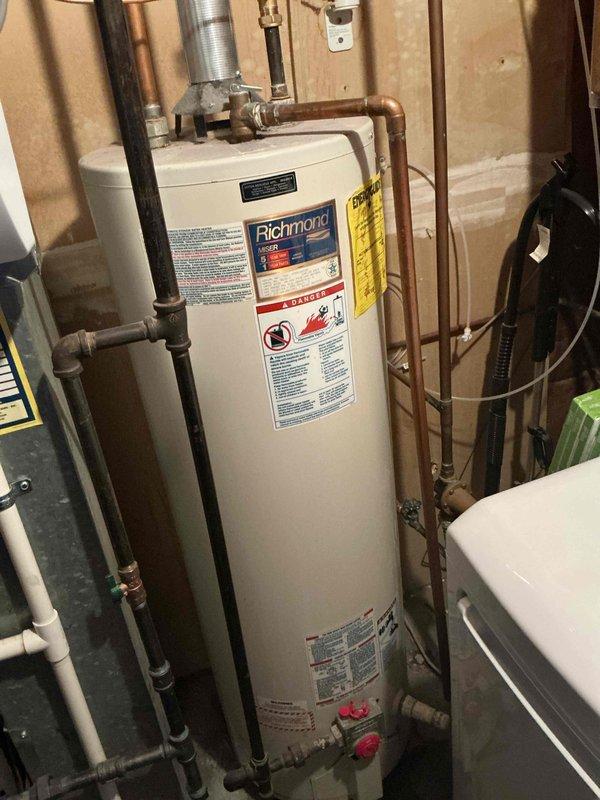Installed a 40-gallon tall gas water heater in residential basement utility area. Connected copper supply and discharge piping to unit with appropriate shut-off valves and fittings, and installed metallic vent ducting for proper exhaust ventilation. Applied required plumbing identification sticker and completed installation per permit requirements.