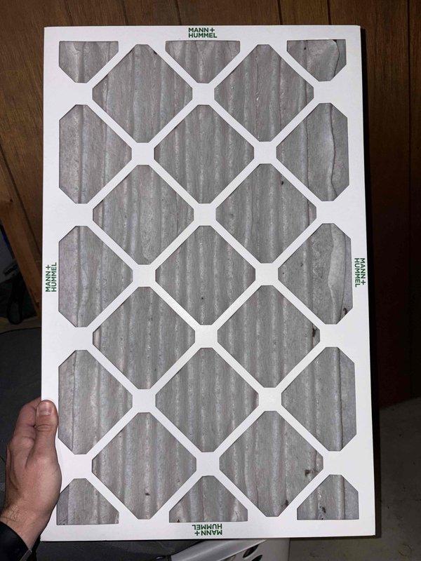 Completed cooling system tune-up on residential air conditioning unit over 10 years old located in side yard. Performed comprehensive system inspection including electrical components, control board, and wiring connections. Inspected and documented MANN+HUMMEL air filter showing normal dust accumulation from use. Verified proper operation of all electrical controls, relays, and safety devices on control board. All components found functioning within normal parameters for unit age.