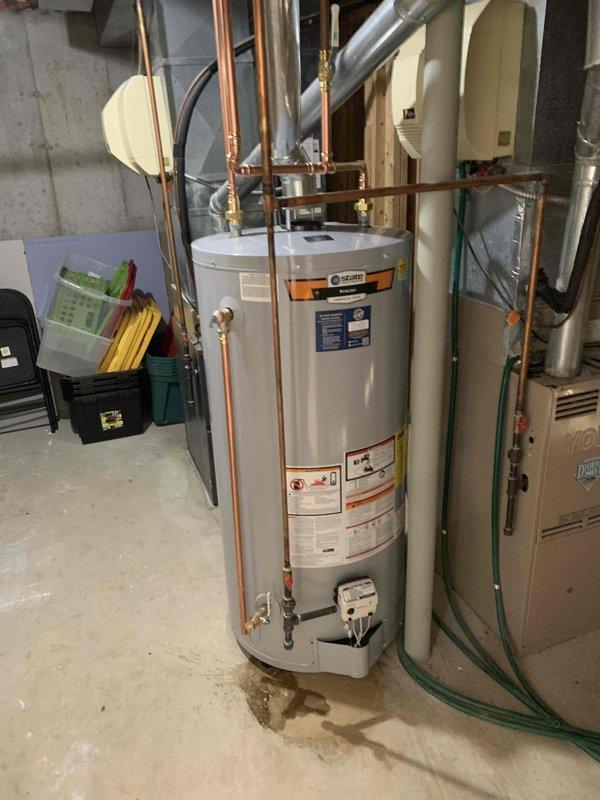 Completed installation of 75-gallon tall gas water heater in basement utility area with proper venting and copper piping connections. Installed 3/4" pressure reducing valve with gauge to regulate incoming water pressure and 1-1/2" full port threaded lead-free ball valve for system isolation. Replaced exterior frost-free hose bib with 10" frost-proof model to prevent freeze damage, completing work that could not be finished during initial water heater installation. All installations performed under permit 26plu-08683 with required plumbing identification stickers applied per code requirements.