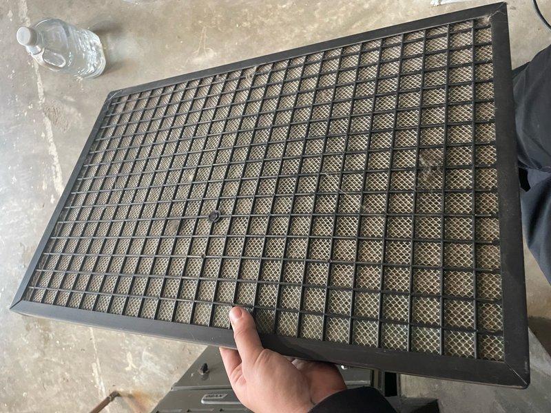 Completed AC tune-up on single ground-level unit located in garage area. Inspected and replaced heavily soiled return air filter showing significant dust and debris accumulation. Cleaned return air grille which exhibited substantial buildup of dirt, dust, and fibrous material behind louvers, restricting proper airflow to system.