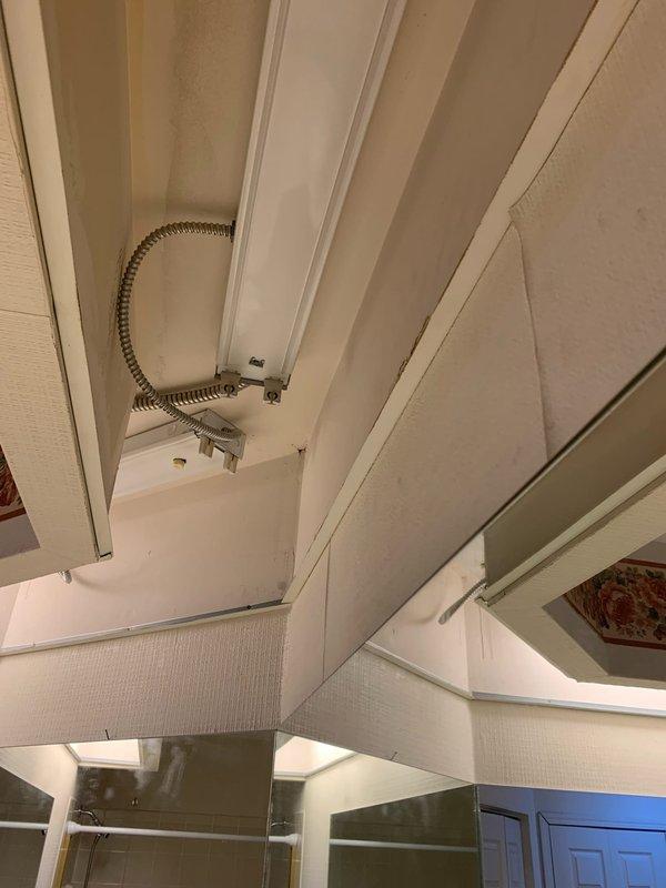 Replaced recessed fluorescent light fixtures in main bathroom area as requested. Customer supplied new fixtures for installation. Removed existing fixtures, installed flexible metallic conduit for electrical connections, and mounted replacement fluorescent lighting units to ceiling structure in accordance with electrical code requirements.