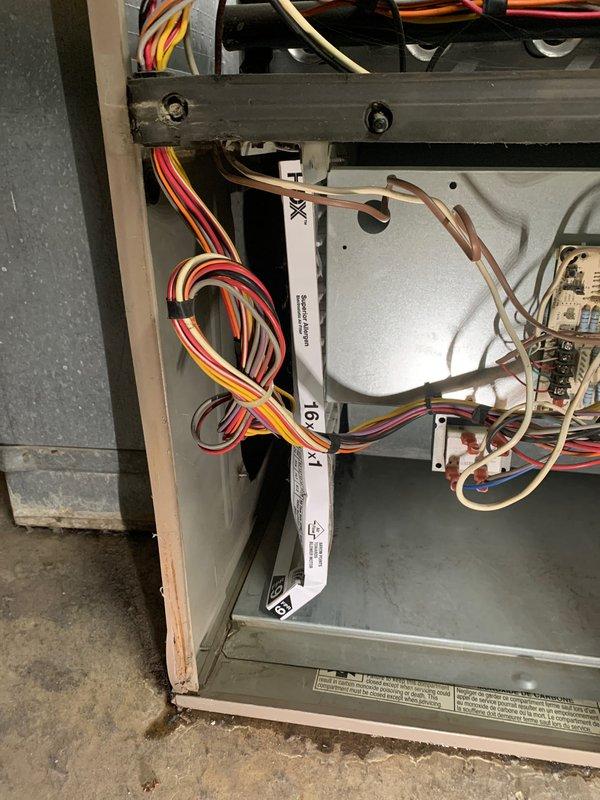 Completed seasonal tune-up and safety inspection on 50-year-old residential HVAC system located at side of house. Performed comprehensive maintenance including visual inspection of control board, electrical connections, and wiring harnesses; verified all wire bundles were properly secured with cable ties and routed correctly throughout cabinet; checked capacitor condition and mounting; inspected ignition module and control components for proper operation; examined copper refrigerant lines for damage or wear; confirmed all safety controls and electrical connections were secure and functioning within manufacturer specifications. Unit tested and left in proper working order with no deficiencies noted; all components clean and well-maintained with organized wiring and no visible signs of deterioration.
