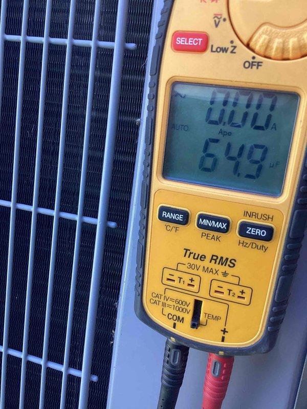 # HVAC Tune-Up Completed

Performed comprehensive preventive maintenance tune-up on a 10-year-old residential air conditioning unit located at side of home. Conducted electrical diagnostics using digital multimeter to verify system amperage draw and temperature readings at condenser coil assembly, with measurements indicating 0.00A and 549°F recorded during testing sequence. Inspected condenser coil fins, which were found to be in good condition with proper alignment and no visible debris accumulation or damage requiring corrective action.