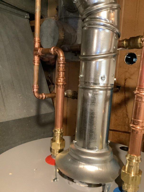 Installed a 40-gallon electric tall water heater in basement utility area, including complete copper piping connections with brass fittings, blue expansion tank mounted to supply lines, and proper venting configuration. Unit was set on white platform base with all code-compliant plumbing connections, pressure relief valve, and shut-off valves properly installed and tested for operation.