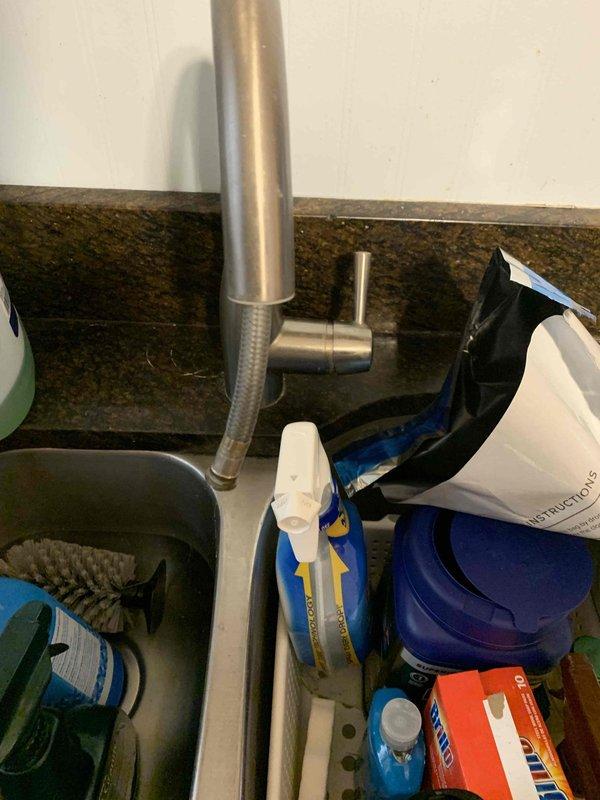 # Plumbing Service Completed

Responded to a kitchen sink drain obstruction in a 60-year-old residential property. Upon arrival, found that a component of the sink drain assembly had broken off, and a plumbing snake had been inserted into the drain line but became lodged and irretrievable deep within the piping system.

Inspected the under-sink plumbing configuration, which included white PVC P-trap assembly, water filtration canister, and standard drain connections. Assessed the stuck snake location and determined extraction methods. Due to the age of the home's plumbing system and the depth at which the snake was lodged, disassembly of drain components was necessary to access and remove the obstruction.

Removed the broken sink drain component and successfully extracted the lodged plumbing snake from the drain line. Cleared any remaining debris and blockage from the affected piping. Reassembled the drain system with proper connections, ensuring all PVC joints were secure and leak-fre