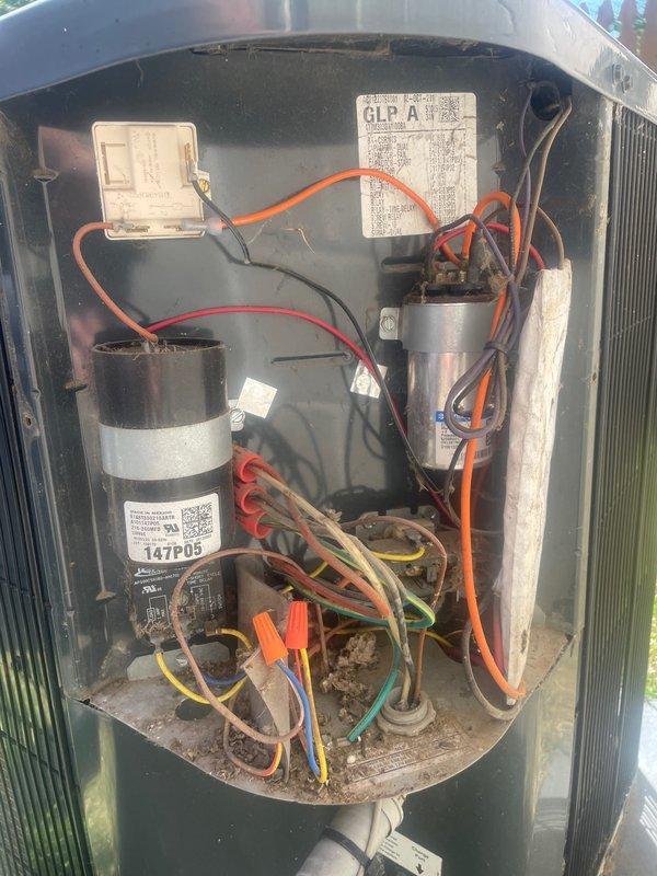 Completed comprehensive cooling tune-up on single outdoor AC unit located at side of residence. Performed full system inspection revealing dirty condenser coils with significant dust and debris accumulation affecting heat transfer efficiency, inspected electrical components including dual capacitors and wiring connections, and documented unit condition with interior access panel removed showing operational capacitors, color-coded wiring with wire nuts, and accumulated dirt in base compartment indicating normal service wear.