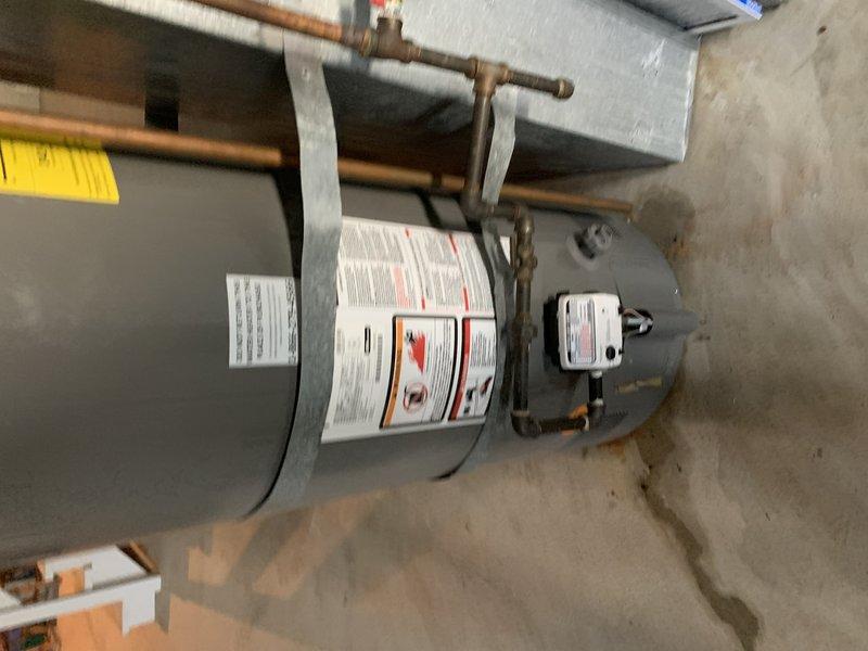 Completed installation of 50-gallon tall gas water heater in basement to replace failed unit that was actively leaking. Installed new flue pipe and seismic restraint straps per code requirements. Connected copper supply lines to inlet and outlet ports with proper shut-off valves and installed temperature/pressure relief valve with discharge piping. Verified all gas connections, tested for leaks, and confirmed proper venting through existing flue system. Unit tested and operational with no leaks detected upon completion.