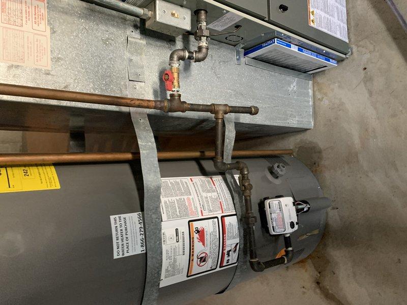 Completed installation of 50-gallon tall gas water heater in basement to replace failed unit that was actively leaking. Installed new flue pipe and seismic restraint straps per code requirements. Connected copper supply lines to inlet and outlet ports with proper shut-off valves and installed temperature/pressure relief valve with discharge piping. Verified all gas connections, tested for leaks, and confirmed proper venting through existing flue system. Unit tested and operational with no leaks detected upon completion.