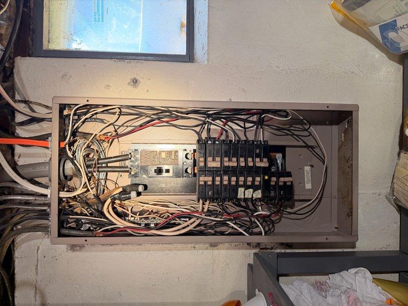Completed comprehensive electrical inspection of residential property. Performed thorough evaluation of main electrical panel, documenting interior breaker configuration with approximately 12-14 standard residential circuit breakers mounted on bus bars, assessed wire management and routing of multiple conductors throughout panel enclosure. Inspected exterior electrical service equipment including meter housing, protective enclosures, and associated conduit system running across building exterior siding, verifying proper mounting and connections to service panel. Documented all findings with detailed photography for homeowner records.