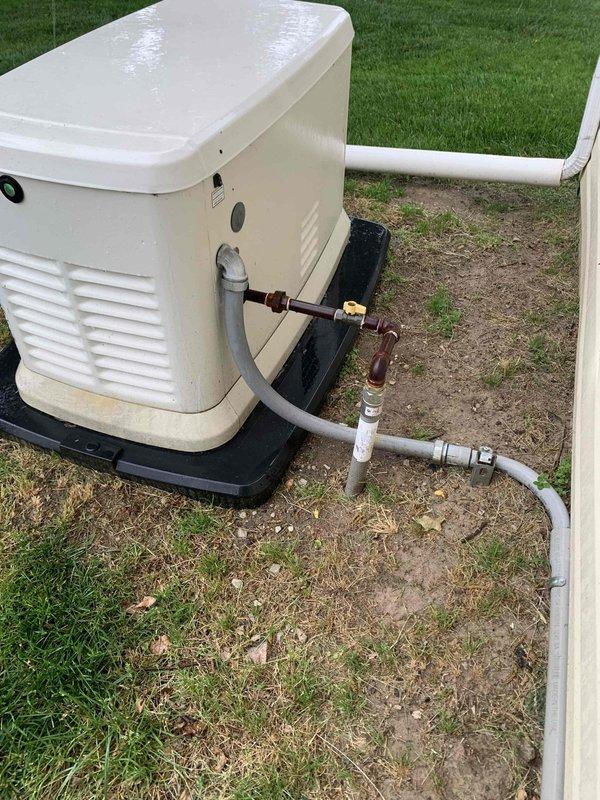 Returned to site to inspect electrical meter in coordination with Metro Electric. Documented existing outdoor electrical infrastructure including residential standby generator installation with associated gas supply line, shut-off valve, sediment trap, and conduit connections. Photographed generator unit mounted on concrete pad with proper ventilation and safety components, as well as exterior utility connections and piping configurations for service records.