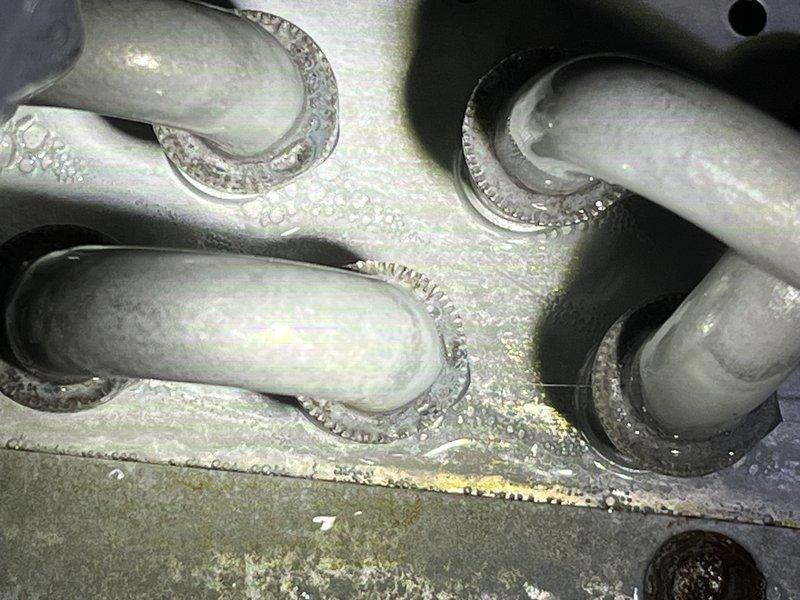 Returned to address frozen evaporator coil condition initially diagnosed on previous visit. Documented extensive frost and ice buildup on refrigerant lines and metal panel surfaces, indicating potential refrigerant restriction, airflow deficiency, or system charge issues. Collected photographic evidence of ice accumulation on line penetrations and surrounding components for repair recommendation and customer approval before proceeding with corrective measures.