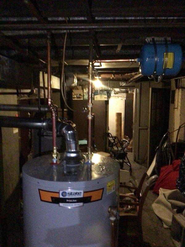Removed and disposed of existing failed water heater from basement mechanical room. Installed new State ProLine 50-gallon tall residential water heater with proper connections to existing copper supply lines and discharge piping. Connected pressure relief valve with code-compliant discharge tube termination. Verified all water and gas connections for proper operation and tested unit for leaks. System operational and ready for service.