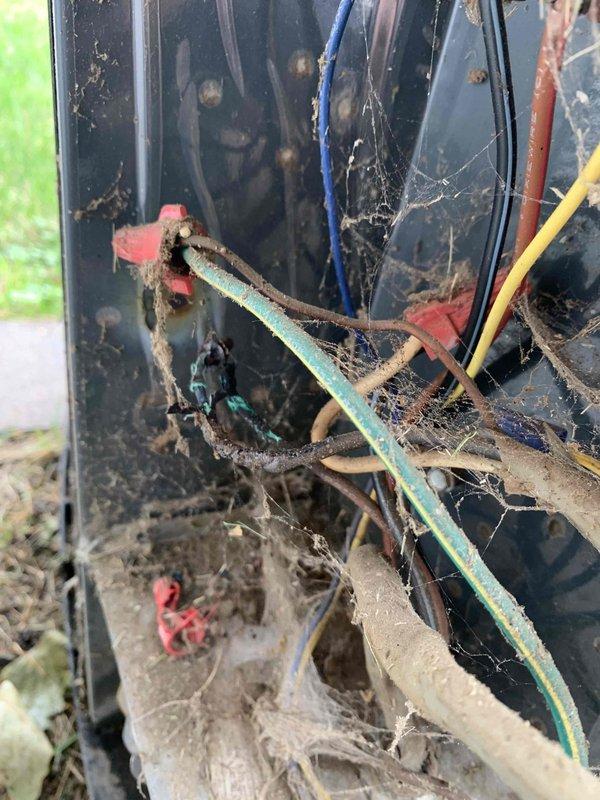 Responded to no cooling complaint on 10+ year old outdoor unit. Upon inspection, found condenser coil completely blocked with heavy accumulation of grass clippings, hay, and dried vegetation restricting airflow. Electrical compartment also contained significant debris, dirt buildup, and cobwebs throughout wiring connections. Removed all organic material from coil fins and internal components, cleaned electrical connections, and verified proper system operation with restored airflow and cooling capacity.