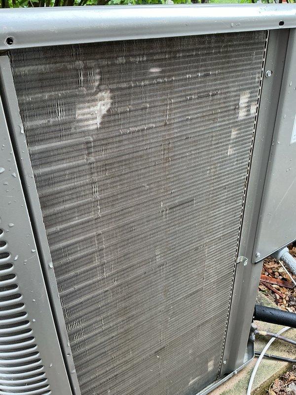 Completed preventive maintenance tune-up on two ground-level air conditioning units. Inspected condenser coils on both outdoor units, noting significant accumulation of dirt, dust, and debris with visible mineral deposits requiring attention. Replaced 20x25x1 air filter showing moderate dust loading. Performed standard cooling system diagnostics and operational checks on both units to ensure proper performance for the upcoming season.