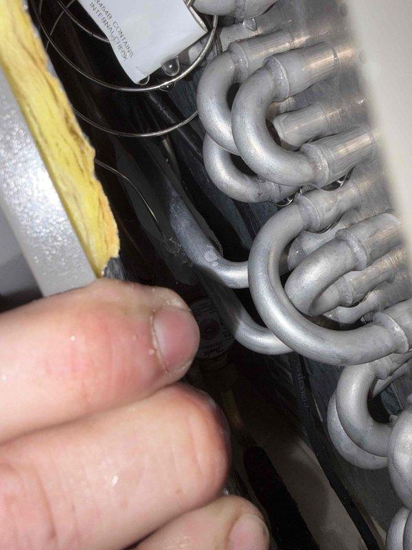 Responded to service call for newly installed A/C unit running 5 degrees above setpoint with condensate lines dripping water in basement. Upon inspection, verified evaporator coil operation and checked refrigerant lines for proper insulation and airflow. System assessed under first-year warranty coverage, with diagnostic photos documenting equipment condition and installation components.