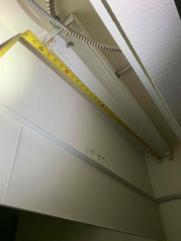 Completed installation of new fluorescent light fixtures per approved estimate. Mounted white linear fluorescent fixture to ceiling with proper measurements and alignment verified using measuring tape. Routed flexible metallic conduit along wall surface to fixture location, ensuring secure attachment and code-compliant installation. All electrical connections completed, fixtures tested and verified operational upon completion.