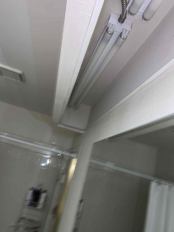 Completed installation of new fluorescent light fixtures per approved estimate. Mounted white linear fluorescent fixture to ceiling with proper measurements and alignment verified using measuring tape. Routed flexible metallic conduit along wall surface to fixture location, ensuring secure attachment and code-compliant installation. All electrical connections completed, fixtures tested and verified operational upon completion.