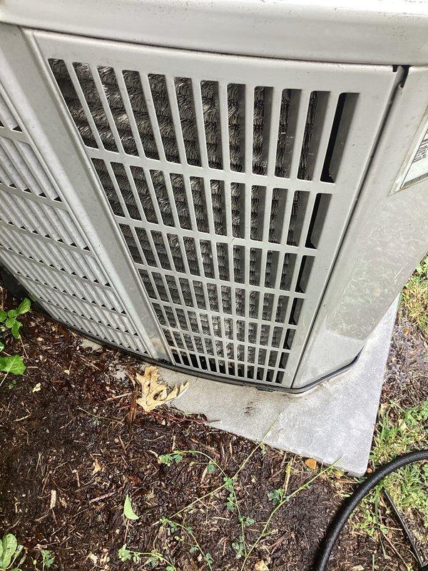 Completed preventive maintenance tune-up on a 2010 outdoor condensing unit located at ground level on side of home. Performed comprehensive system inspection, cleaned condenser coils which showed moderate accumulation of dirt, dust, and debris in louvers and grille areas, checked refrigerant levels, tested electrical connections, and verified proper operation of all components. Unit operational upon completion with no immediate repairs required.