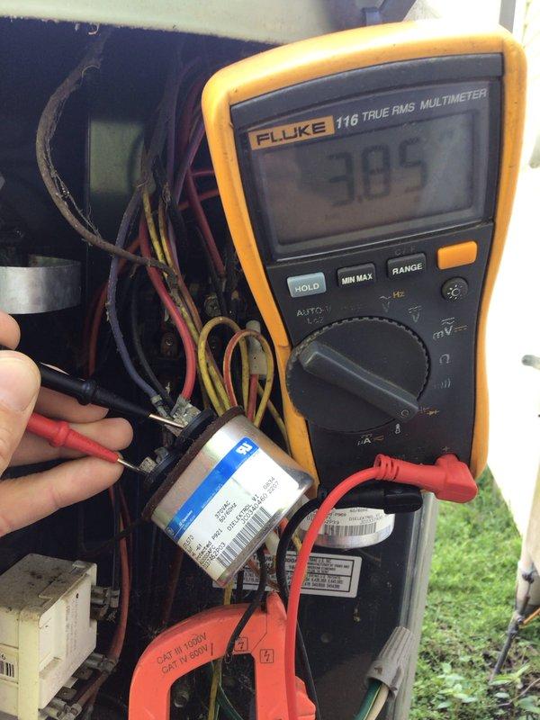 Completed seasonal tune-up maintenance on residential outdoor condensing unit. Upon arrival, found evaporator coil heavily clogged with dirt, dust, and debris significantly restricting airflow through the system. Performed electrical diagnostics using multimeter, obtaining voltage reading of 305V at capacitor terminals. Tested capacitor functionality and verified proper electrical connections throughout the unit. Removed front access panel to expose internal coil assembly for thorough inspection and cleaning. Addressed substantial accumulation of outdoor contaminants on aluminum fin structure to restore proper system airflow and efficiency. All electrical components tested within normal operating parameters upon completion of maintenance service.