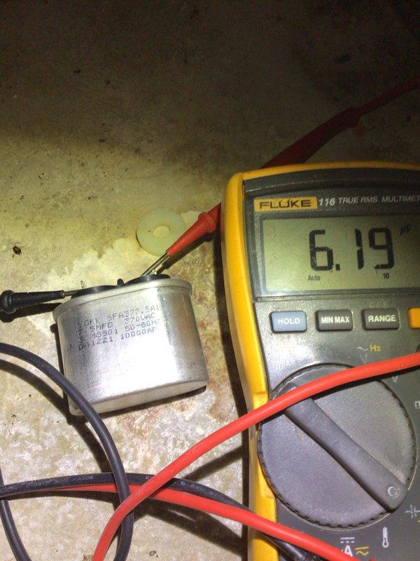 Completed preventive maintenance tune-up on outdoor condensing unit located in side yard. Performed electrical diagnostics using digital multimeter, measuring capacitor functionality and recording voltage reading of 6.19 volts. Inspected control board wiring and connections, verifying proper operation of SureLight circuit board and associated low-voltage wiring harness including multiple circuit connections for system controls and safety devices.