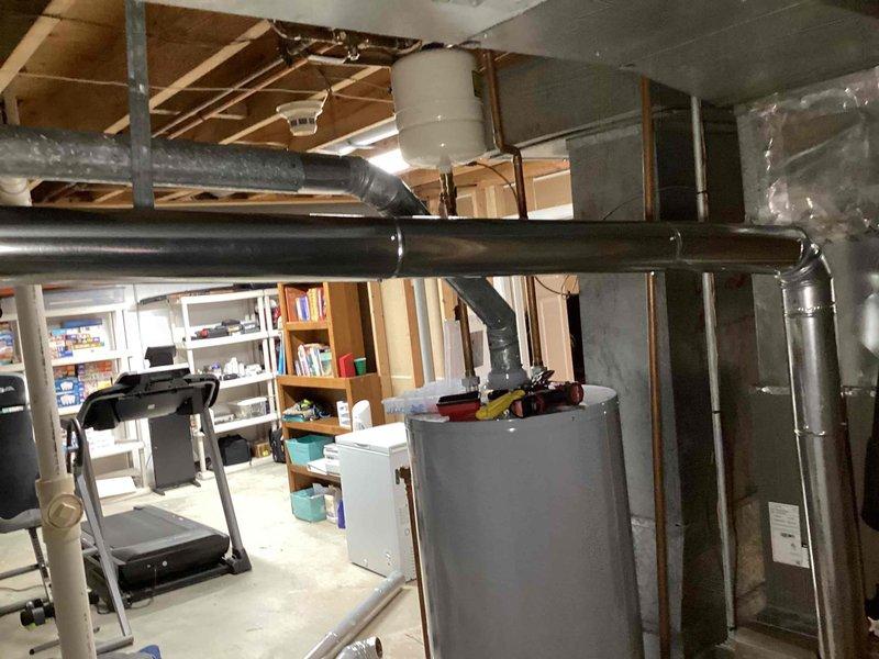 Completed flue pipe repair in basement mechanical room. Installed new 6x4x3 flue tee, 10 feet of 4-inch flue pipe, and two 4-inch elbows to properly vent water heater exhaust system. All components secured and tested for proper operation.