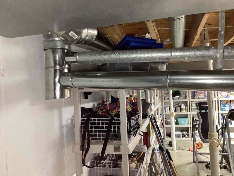 Completed flue pipe repair in basement mechanical room. Installed new 6x4x3 flue tee, 10 feet of 4-inch flue pipe, and two 4-inch elbows to properly vent water heater exhaust system. All components secured and tested for proper operation.