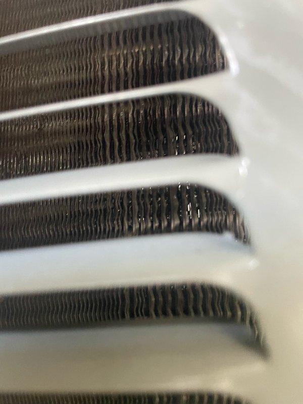 Completed preventive maintenance tune-up on residential HVAC system. Performed comprehensive inspection of evaporator coil assembly, documenting condition of heat exchanger fins and condensate management. All coil rows showed normal operational wear with minor condensation present, indicating proper system function during cooling cycle.