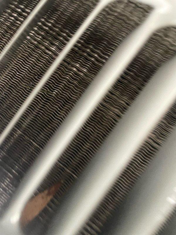 Completed preventive maintenance tune-up on residential HVAC system. Performed comprehensive inspection of evaporator coil assembly, documenting condition of heat exchanger fins and condensate management. All coil rows showed normal operational wear with minor condensation present, indicating proper system function during cooling cycle.