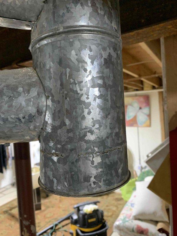 Responded to no cooling complaint on 18+ year old system. Upon arrival, unit was off as reported. Conducted comprehensive diagnostic evaluation of HVAC system and ductwork. Inspection revealed severely deteriorated galvanized ductwork with extensive surface corrosion, flaking zinc coating, and compromised metal integrity throughout multiple sections. The supply duct exhibited significant paint and coating degradation with rust penetration and structural concerns. Documented deteriorated ductwork conditions with photographs showing mottled surface patterns, exposed base metal, and areas of complete coating failure. Assessed system components and identified ductwork replacement as critical need due to age-related deterioration affecting system efficiency and air quality. Presented findings and repair recommendations to property representative who had authorization to approve necessary work. System requires ductwork replacement to restore proper operation and resolve cooling deficiency.