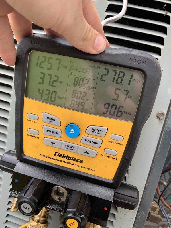 Completed comprehensive cooling system tune-up on 2003 outdoor AC unit. System diagnostics revealed severely corroded orange wire at capacitor requiring immediate attention for safe operation. Recorded refrigerant pressures and temperatures using digital manifold gauges, with suction side reading 125.7 PSIG and discharge side reading 218.1 PSIG. All measurements documented and system evaluated for proper operation and efficiency.