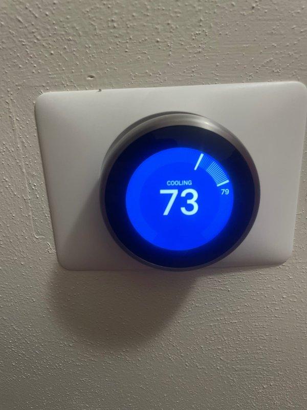 Responded to no cooling complaint on 5-year-old ground-level unit reported to be blowing warm air. Upon arrival, verified thermostat was initially in OFF position showing 79°F ambient temperature. Cycled system into cooling mode and confirmed unit successfully achieved cooling operation with thermostat displaying 73°F setpoint and active cooling status. System operating normally with no freezing observed on coils and proper airflow established.