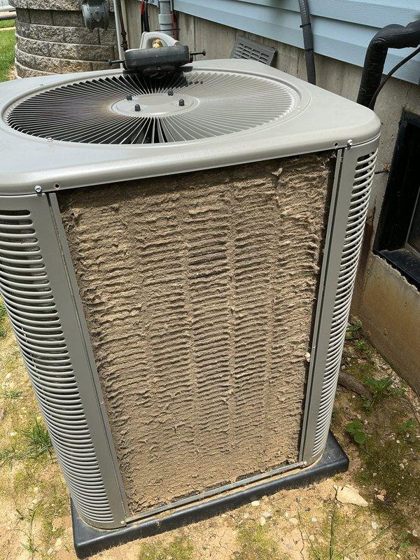 Responded to no cool call on ground-level condenser unit. Found outdoor coil completely blocked with dense accumulation of dirt, dust, lint, and cottonwood debris, restricting all airflow and preventing proper heat rejection. Cleaned condenser coil thoroughly, removing heavy debris buildup from exterior fins. Replaced dirty indoor air filter. Restored unit to normal operation with proper airflow and cooling capacity.