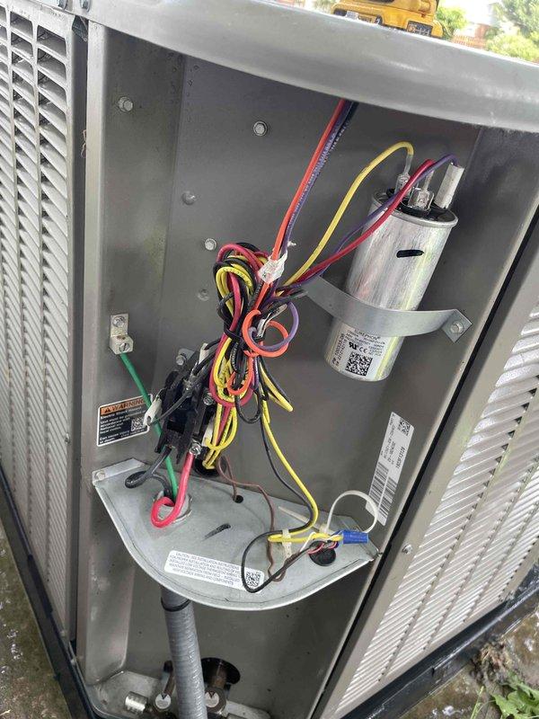 # HVAC Cooling System Maintenance Summary

Completed comprehensive cooling maintenance tune-up on residential outdoor condenser unit. System was found operational upon arrival and remained in working condition throughout service. Performed standard preventative maintenance procedures including inspection of condenser cabinet, electrical components, and capacitor. Verified proper wiring connections and electrical safety. Unit is functioning as designed with no issues identified.

# Detailed Service Description

Performed routine cooling maintenance on residential split system air conditioning unit. Upon arrival, confirmed system was operational and in cooling mode. Conducted thorough visual inspection of outdoor condenser unit positioned on elevated metal stand.

Removed access panel to inspect internal electrical compartment. Examined all electrical connections including red, yellow, black, green, and purple wire terminations for security and proper contact. Inspected cylindrical capac