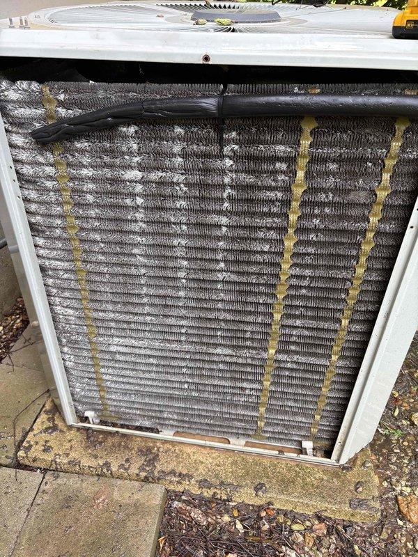 Completed cooling tune-up on outdoor condensing unit over 10 years old located in side yard. Performed standard maintenance protocol including inspection of condenser coil which showed significant accumulation of dirt and pollen with visible yellow streaking throughout fins, inspected internal air handler components and control board assembly, verified all electrical connections and refrigerant lines, and documented system condition with photos. Unit operational upon completion of service.