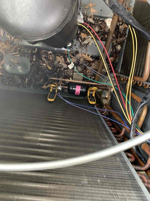 Responded to no cooling complaint requiring senior technician diagnostic. Upon arrival, found system had been previously serviced by two other technicians with ongoing issues. Performed comprehensive diagnostic of refrigerant restriction in R410A system containing approximately 16 pounds of refrigerant. Noted significant debris accumulation including leaves and organic material within air handler compartment and around outdoor condenser coil. Observed oxidation on copper refrigerant lines and filter drier component. Utilized diagnostic gauges to assess system pressures and confirm restriction in refrigerant circuit. Determined large recovery tank required for proper refrigerant recovery and system repair. Documented equipment condition with photos showing debris-laden evaporator coil, discolored copper piping, and contaminated outdoor unit. Recommended thorough system cleaning, refrigerant recovery, restriction repair, and component replacement as needed to restore proper cooling opera