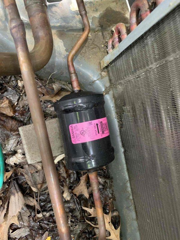 Responded to no cooling complaint requiring senior technician diagnostic. Upon arrival, found system had been previously serviced by two other technicians with ongoing issues. Performed comprehensive diagnostic of refrigerant restriction in R410A system containing approximately 16 pounds of refrigerant. Noted significant debris accumulation including leaves and organic material within air handler compartment and around outdoor condenser coil. Observed oxidation on copper refrigerant lines and filter drier component. Utilized diagnostic gauges to assess system pressures and confirm restriction in refrigerant circuit. Determined large recovery tank required for proper refrigerant recovery and system repair. Documented equipment condition with photos showing debris-laden evaporator coil, discolored copper piping, and contaminated outdoor unit. Recommended thorough system cleaning, refrigerant recovery, restriction repair, and component replacement as needed to restore proper cooling opera