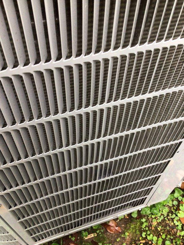 Completed preventative maintenance tune-up on a single outdoor condensing unit manufactured in 2019. Performed comprehensive system inspection including condenser coil examination, verified proper airflow through exterior louvers and fin assembly, and inspected indoor air filtration system. Noted dust accumulation on air filter media during inspection, documenting unit condition with photographic evidence of both outdoor condenser components and indoor filter status to ensure proper system operation and maintenance compliance.