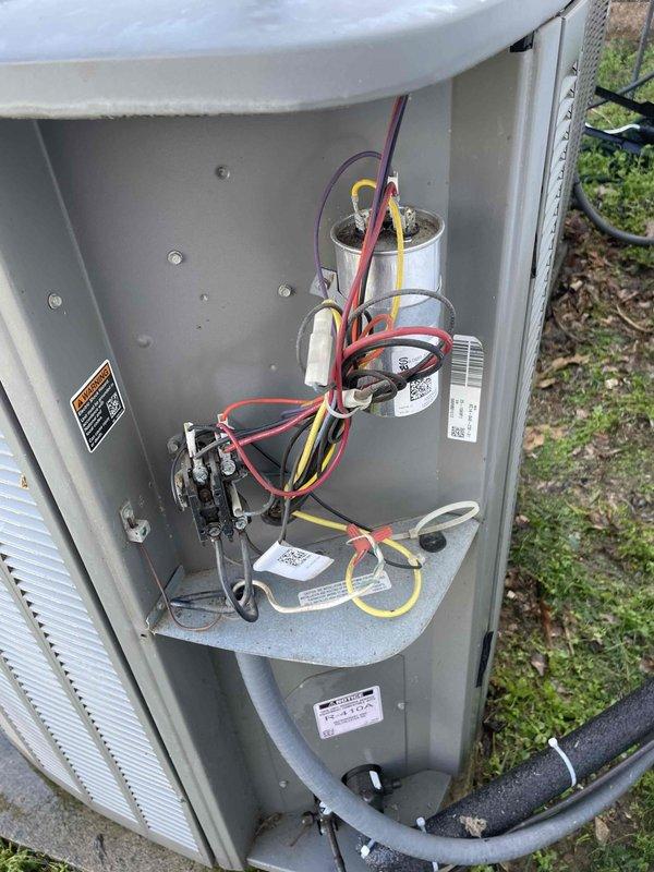Performed comprehensive cooling maintenance on a 9-year-old residential air conditioning system experiencing inadequate cooling capacity and electrical issues causing lights to dim at startup. Completed full system inspection including visual examination of outdoor condenser unit, electrical components, contactor, dual capacitors, and wiring connections. Addressed reported concerns of loud startup noise and insufficient cooling performance. Checked refrigerant levels, tested electrical draw, and evaluated compressor operation. Inspected condenser coils, verified proper airflow through mesh grilles, and assessed overall system functionality. Documented equipment condition with photos showing capacitor configuration, electrical connections, and exterior unit placement on concrete pad with visible weathering consistent with system age.