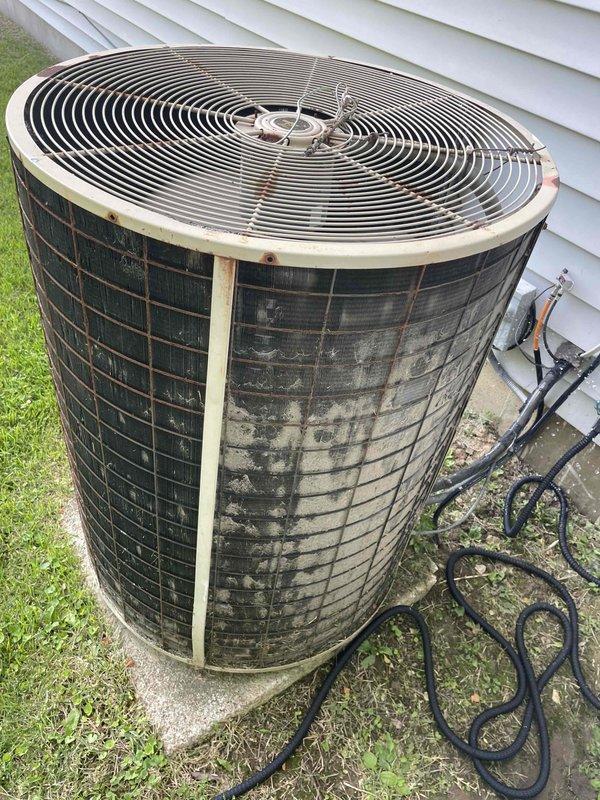 Completed comprehensive tune-up service on single ground-level air conditioning condenser unit. Performed standard maintenance protocol including inspection of exterior components, electrical connections, and refrigerant lines. Evaluated and replaced heavily soiled 20x25x1 air filter showing significant dust accumulation and reduced airflow capacity. Unit exhibited considerable weathering and exterior staining consistent with extended service life, though all mechanical and electrical components were verified operational during inspection.