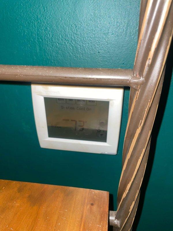 Responded to no cooling complaint on 10+ year old Trane air conditioning system located in basement. Upon arrival, found thermostat displaying "Cool On" but inadequate cooling throughout home. Inspected air handler and confirmed air filters were dirty and restricting airflow, which can cause reduced cooling capacity and system inefficiency. Documented current system conditions including thermostat settings, refrigerant line configuration, and filter housing assembly. Provided photos of existing equipment status for service records. Recommended filter replacement and further system evaluation to address ongoing cooling performance issues.