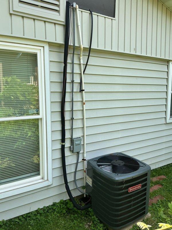 Responded to no cooling complaint caused by clogged condensate drain line with water overflow from secondary drain. Previous technician had cleared both primary and secondary drains; returned to complete permanent repair of exterior drain line. Installed 3/4-inch PVC coupling to repair damaged section of condensate drain piping on exterior wall. Verified primary and secondary drain lines flowing freely with no restrictions. Inspected air filter condition and confirmed proper system operation with adequate cooling performance restored.