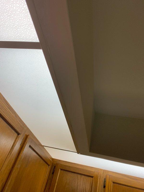Completed installation of LED lighting fixtures in kitchen area. Installed 8-12 new LED light fixtures in soffit space above cabinetry, providing enhanced illumination for the workspace. All fixtures tested and confirmed operational upon completion.
