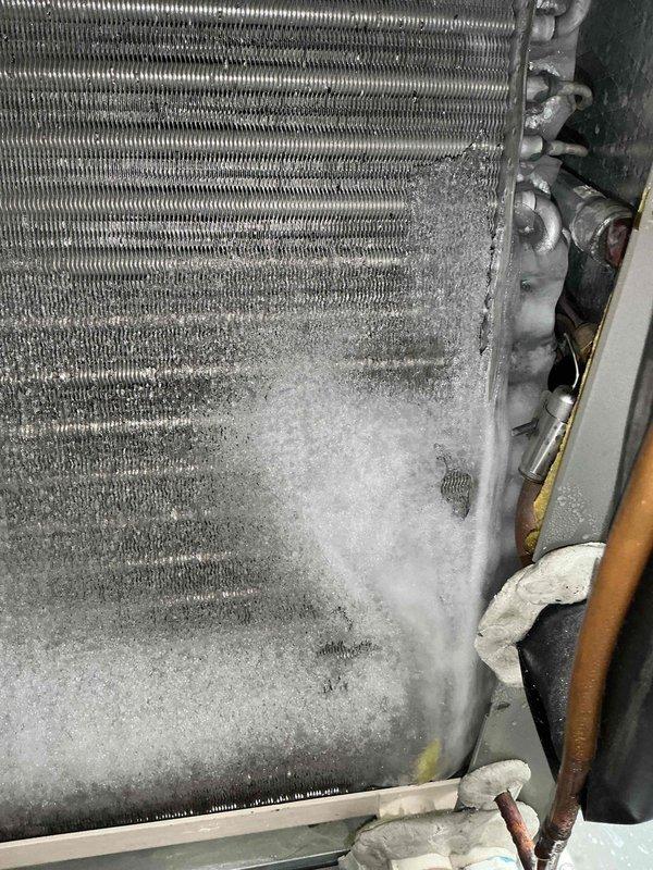 Responded to no cooling complaint on 2-year-old unit that had been off for 6 hours. Upon arrival, found evaporator coil completely frozen with heavy ice and frost buildup covering lower two-thirds of coil assembly. Identified restricted airflow as root cause of freeze condition. Shut down system to allow complete ice melt, inspected and replaced dirty air filter that was blocking airflow to evaporator coil. Verified all supply registers were open and unobstructed. Once coil fully defrosted, restarted system and monitored operation through complete cooling cycle. Confirmed proper airflow across coil, adequate temperature split, and normal system operation with no further icing. Advised on importance of regular filter maintenance to prevent future freeze-ups.